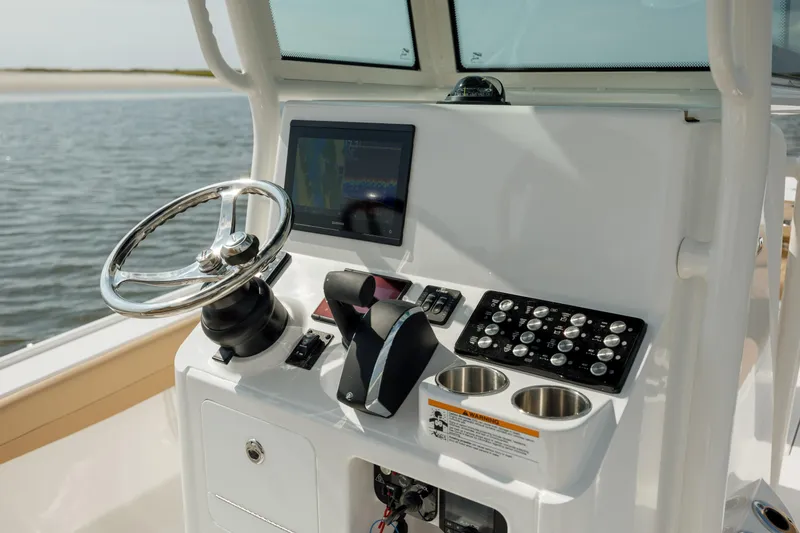 Slide: The Image of 2025 Caymas 26 HB boat dashboard with steering wheel and controls. - 17