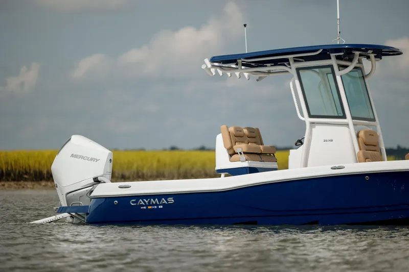 Slide: The Image of 2025 Caymas 26 HB boat on water, featuring a sleek blue and white design. - 4