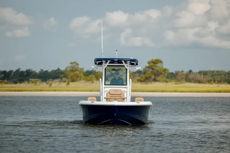 Slide: The Image of 2025 Caymas 26 HB boat cruising on calm water with scenic background. - 9