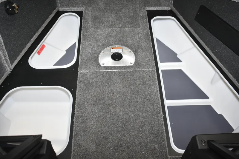 Slide: The Image of 2026 Alumacraft Competitor 195X Sport interior storage compartments with carpeted flooring. - 11