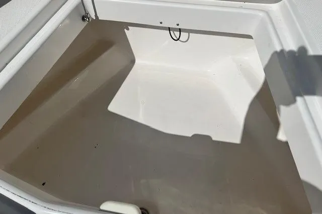 Slide: The Image of Storage compartment of a 2018 Everglades 335 Center Console boat, featuring a clean, spacious interior. - 13