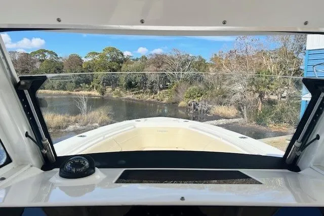 Slide: The Image of 2018 Everglades 335 Center Console boat view from helm, overlooking serene waterway. - 29