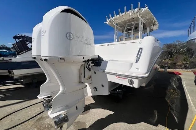 Slide: The Image of 2018 Everglades 335 Center Console boat with dual Yamaha outboard engines, docked under clear skies. - 3
