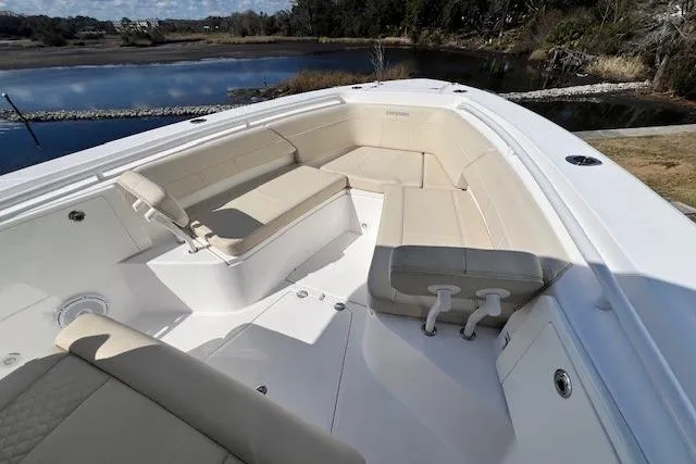 Slide: The Image of 2018 Everglades 335 Center Console boat with spacious seating, docked by a serene lake. - 45