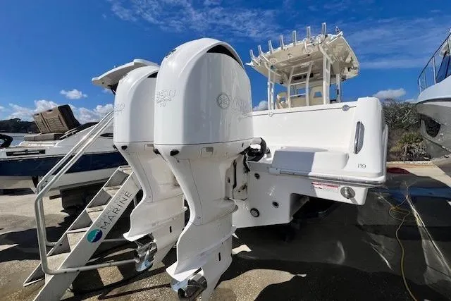 Slide: The Image of 2018 Everglades 335 Center Console boat with dual outboard engines, docked under clear skies. - 51