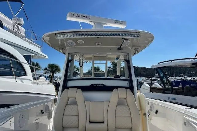 Slide: The Image of 2018 Everglades 335 Center Console boat with Garmin radar, docked under clear blue sky. - 8