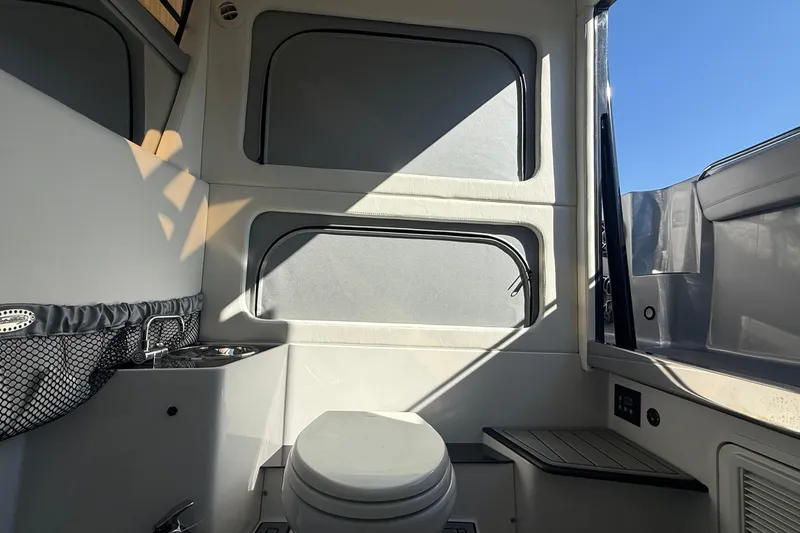 Slide: The Image of 2023 Nor-Tech 390 Sport Center Console interior with toilet and sink, featuring modern design. - 24