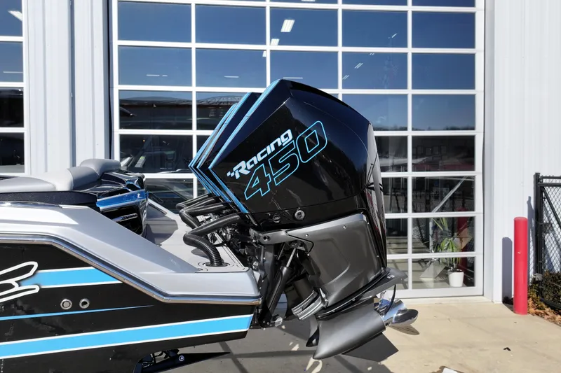 Slide: The Image of 2023 Nor-Tech 390 Sport Center Console with Racing 450 engine, parked outside a garage. - 28