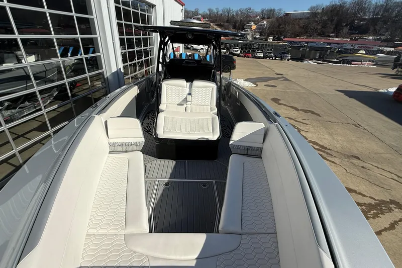 Slide: The Image of 2023 Nor-Tech 390 Sport Center Console with luxurious seating and sleek design in a marina setting. - 8
