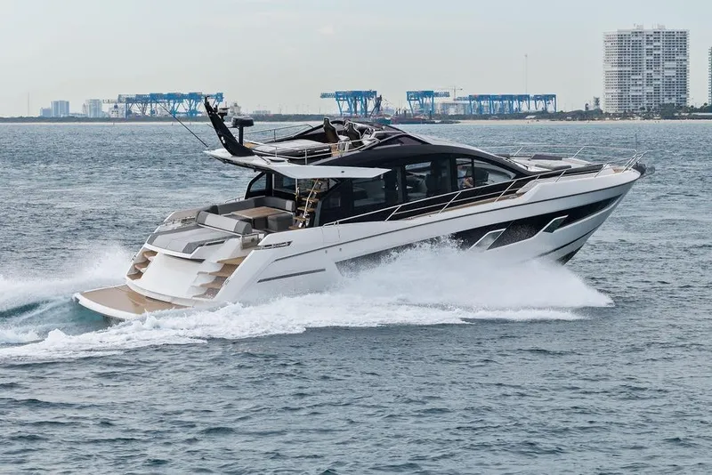 Slide: The Image of 2022 Sunseeker 65 Sport Yacht cruising on open water near city skyline. - 11