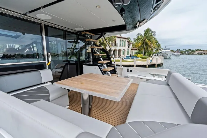 Slide: The Image of Luxurious 2022 Sunseeker 65 Sport Yacht with elegant seating and scenic waterfront view. - 52
