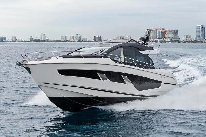 Slide: The Image of 2022 Sunseeker 65 Sport Yacht cruising on open water near city skyline. - 7