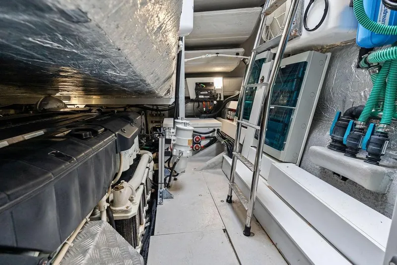 Slide: The Image of Engine room of 2022 Sunseeker 65 Sport Yacht, featuring mechanical components and ladder access. - 81