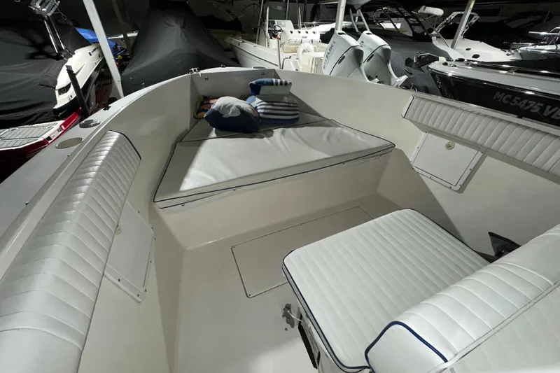 Slide: The Image of 2006 Clearwater 2508 boat interior with cushioned seating and pillows. - 10