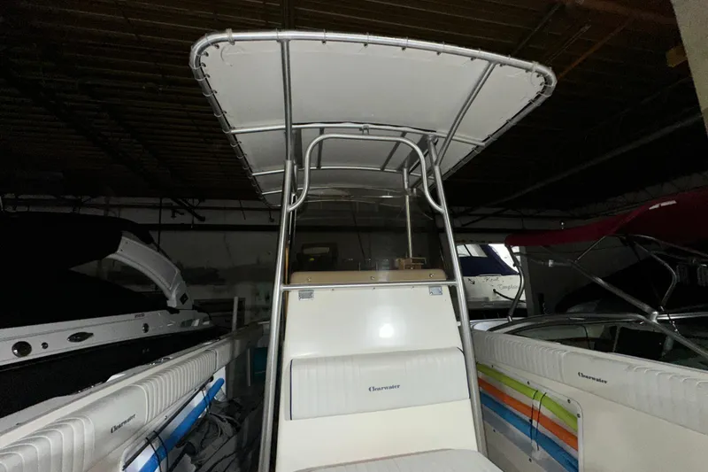 Slide: The Image of 2006 Clearwater 2508 boat with T-top in storage, featuring colorful interior accents. - 12