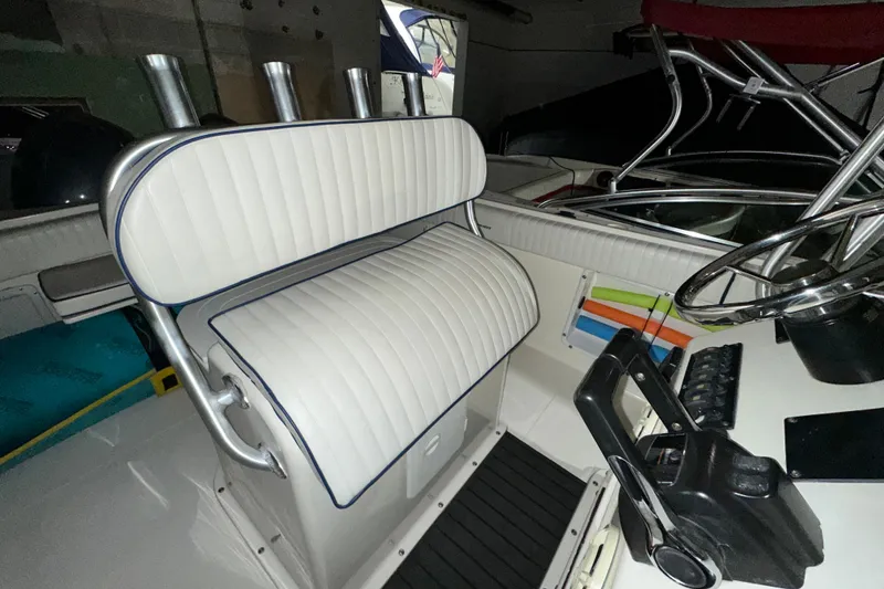 Slide: The Image of 2006 Clearwater 2508 boat interior with white cushioned seating and steering wheel. - 7