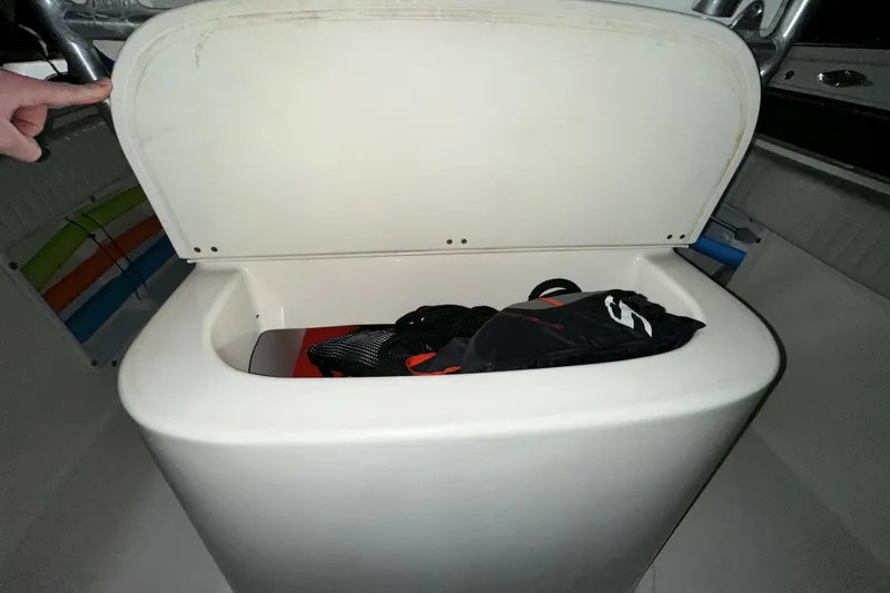 Slide: The Image of Open storage compartment in a 2006 Clearwater 2508 boat, containing a black bag. - 5