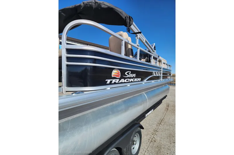 Slide: The Image of 2022 Sun Tracker Fishin' Barge 22 DLX pontoon boat on trailer, side view. - 3
