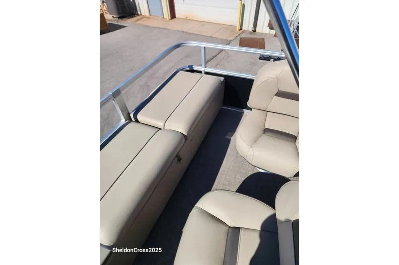 Slide: The Image of 2022 Sun Tracker Fishin' Barge 22 DLX interior with beige seating and storage. - 9