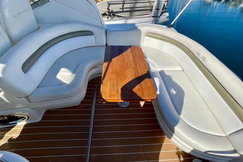 Slide: The Image of 2007 Sea Ray 340 Sundancer boat interior with curved seating and wooden table. - 26