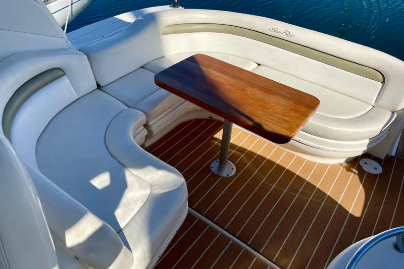 Slide: The Image of 2007 Sea Ray 340 Sundancer boat interior with white seating and wooden table. - 27