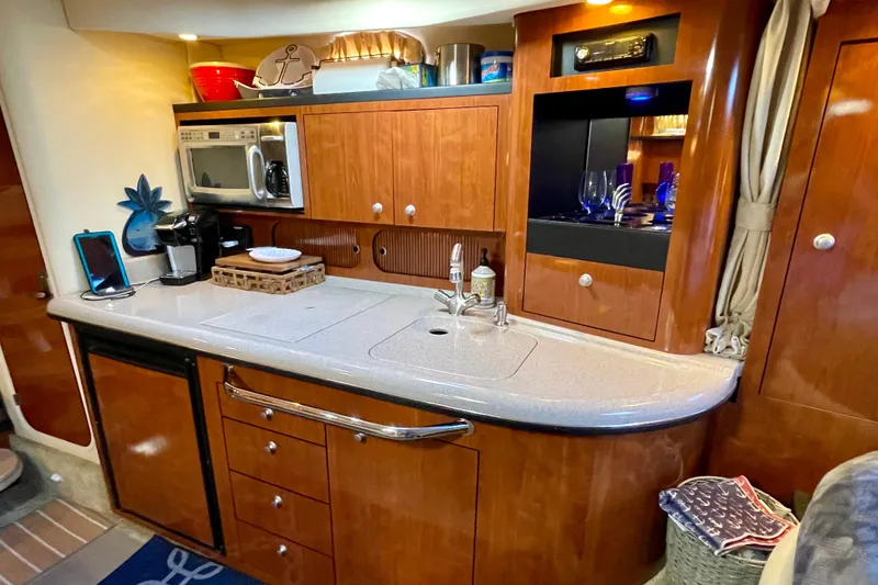 Slide: The Image of 2007 Sea Ray 340 Sundancer galley with wood cabinetry, sink, microwave, and storage. - 37