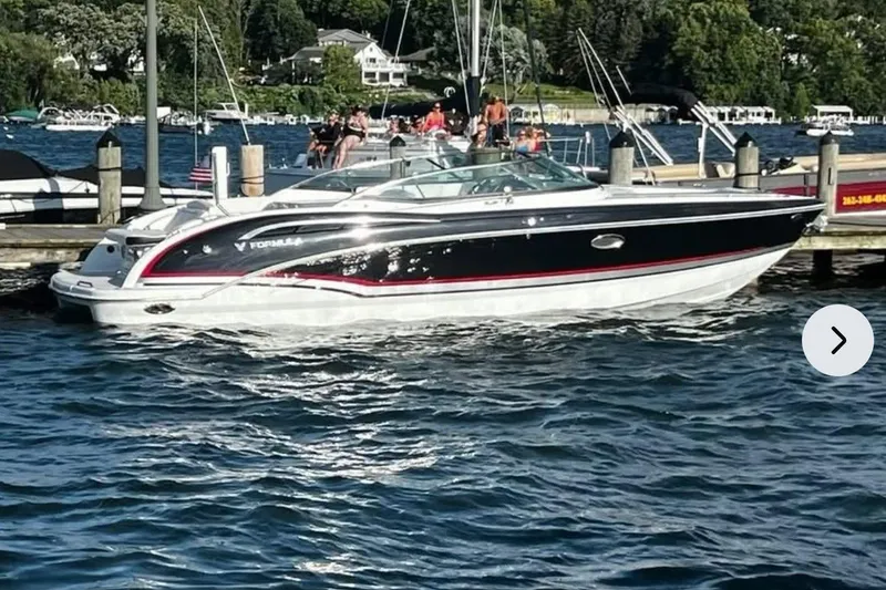 Slide: The Image of 2014 Formula 310 Bowrider boat docked on a sunny day by the lake. - 5