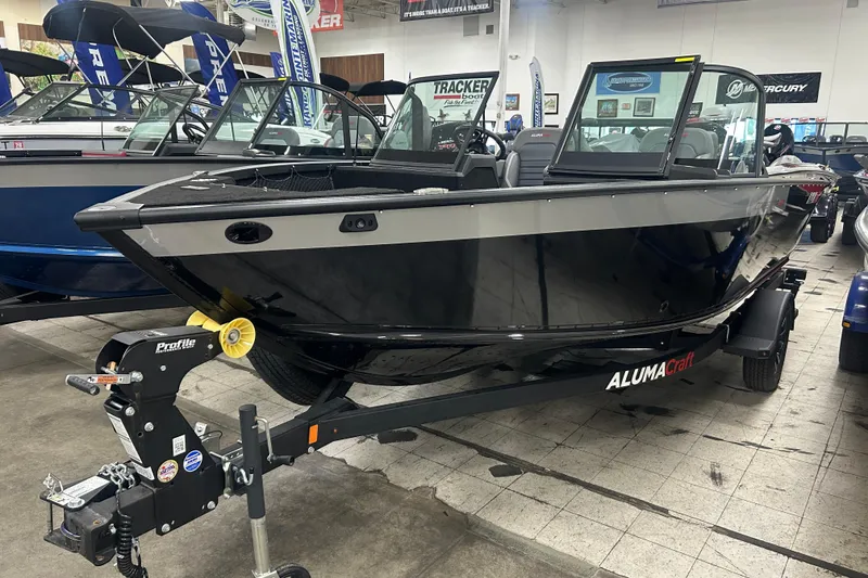 The Image of 2026 Alumacraft Competitor 185X Sport boat displayed indoors on a trailer. - 0