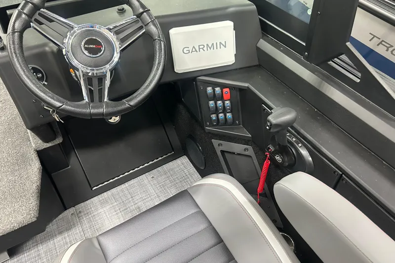 Slide: The Image of 2026 Alumacraft Competitor 185X Sport boat cockpit with Garmin system and steering wheel. - 13
