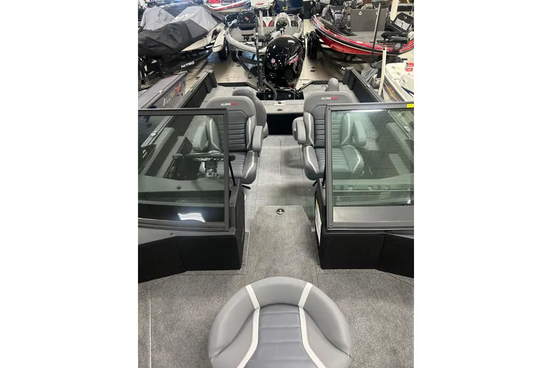 Slide: The Image of 2026 Alumacraft Competitor 185X Sport boat interior with seating and windshield, displayed indoors. - 15