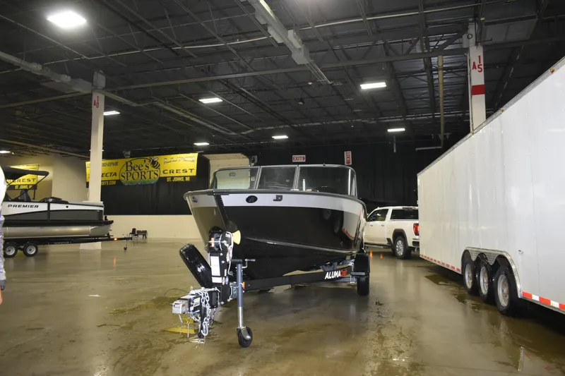 Slide: The Image of 2026 Alumacraft Competitor 185X Sport boat displayed indoors with trailer and truck. - 5