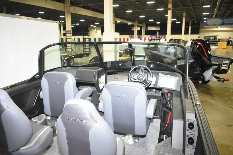 Slide: The Image of 2026 Alumacraft Competitor 185X Sport boat interior with steering wheel and seating. - 7
