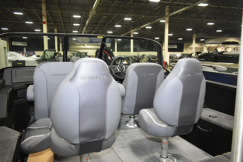 Slide: The Image of 2026 Alumacraft Competitor 185X Sport boat interior with gray seating in showroom. - 8
