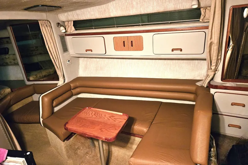 Slide: The Image of 1990 Sea Ray Sundancer 310 interior with brown leather seating and wooden table. - 11