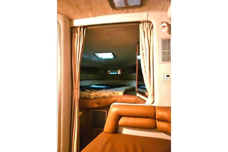 Slide: The Image of Interior of 1990 Sea Ray Sundancer 310, featuring cozy cabin with seating and bed. - 12