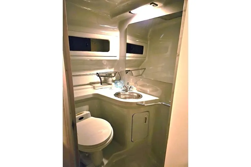 Slide: The Image of 1990 Sea Ray Sundancer 310 bathroom with sink, toilet, and storage. - 16