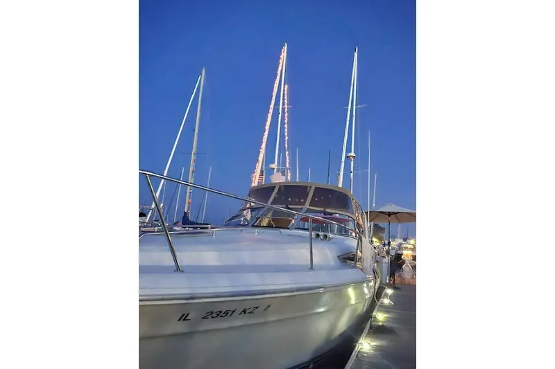 Slide: The Image of 1990 Sea Ray Sundancer 310 docked at marina during evening. - 2