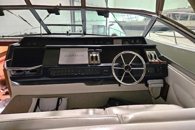 Slide: The Image of 1990 Sea Ray Sundancer 310 helm with Garmin navigation system and classic steering wheel. - 6