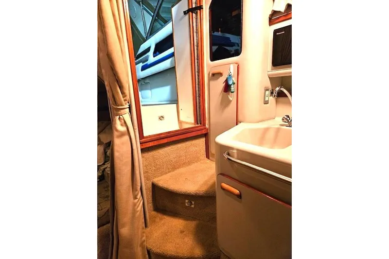 Slide: The Image of Interior of 1990 Sea Ray Sundancer 310, featuring stairs and a compact sink area. - 9