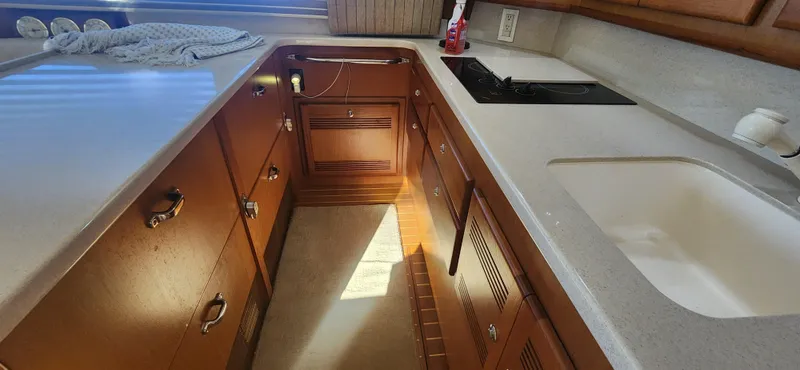 Slide: The Image of 2004 Cabo 48 Convertible yacht kitchen with wooden cabinets and modern appliances. - 17