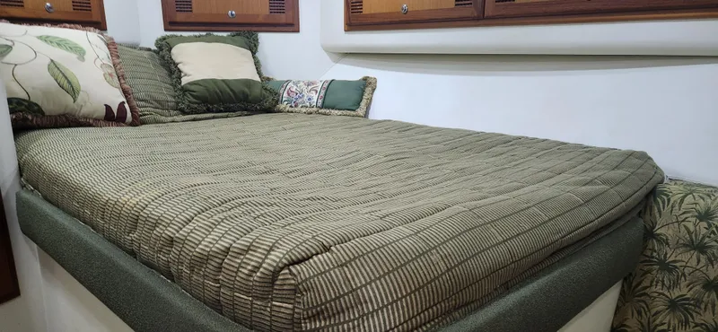 Slide: The Image of 2004 Cabo 48 Convertible cabin with cozy bed and decorative pillows. - 26