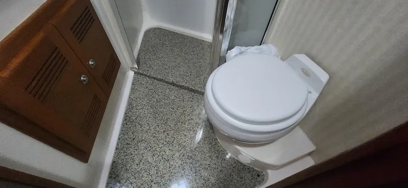 Slide: The Image of Bathroom interior of 2004 Cabo 48 Convertible yacht, featuring a toilet and shower area. - 34