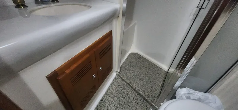 Slide: The Image of 2004 Cabo 48 Convertible bathroom with sink, wooden cabinet, and shower area. - 38