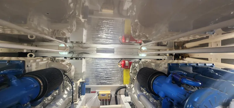 Slide: The Image of Engine room of a 2004 Cabo 48 Convertible yacht, featuring dual engines and mechanical components. - 39