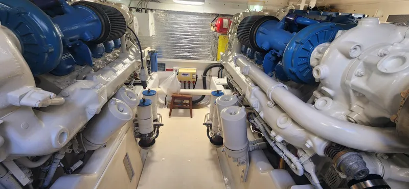Slide: The Image of Engine room of a 2004 Cabo 48 Convertible yacht, featuring dual engines and mechanical components. - 41