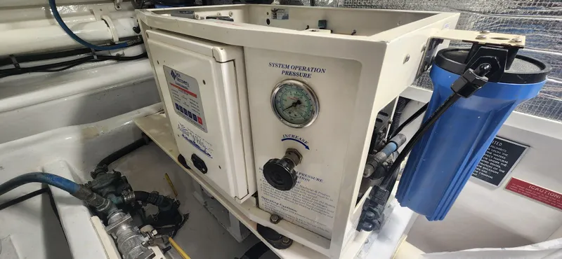 Slide: The Image of Engine room of 2004 Cabo 48 Convertible with water filtration system and pressure gauge. - 42