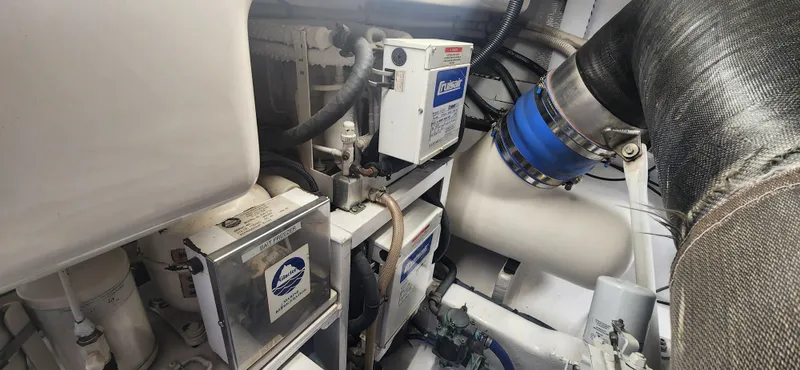 Slide: The Image of Engine room of a 2004 Cabo 48 Convertible yacht, showcasing mechanical components. - 43