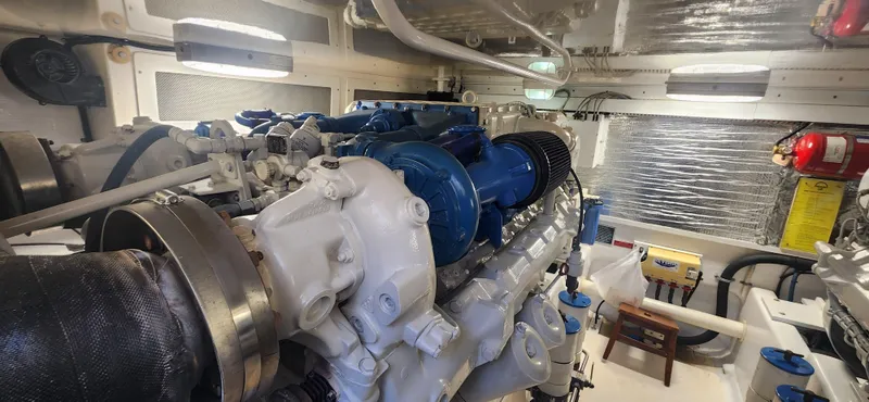 Slide: The Image of Engine room of a 2004 Cabo 48 Convertible yacht, showcasing a powerful marine engine. - 44