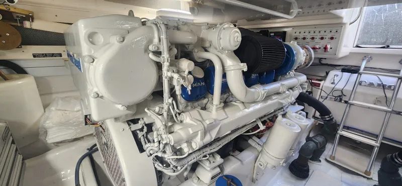 Slide: The Image of Engine room of a 2004 Cabo 48 Convertible yacht, showcasing a clean, well-maintained engine. - 48