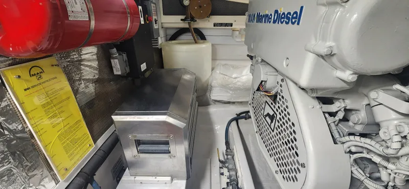 Slide: The Image of Engine room of 2004 Cabo 48 Convertible with marine diesel engine and safety equipment. - 49